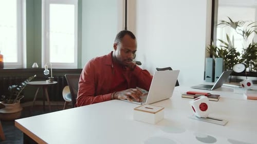 Young African American Man Working on Laptop in Office