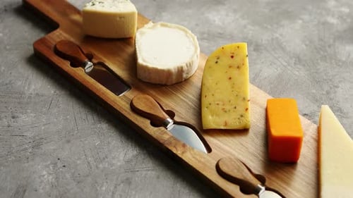 Gourmet Cheeses Displayed on a Wooden Cheese Board
