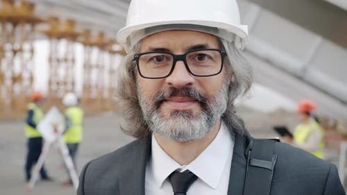 Smiling Engineer Wearing Hardhat at Construction Site