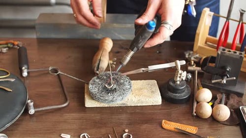 Jeweler Using Torch to Craft Jewelry at Workbench