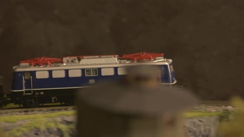 Locomotiva ferroviária de brinquedo a diesel em movimento pela floresta.