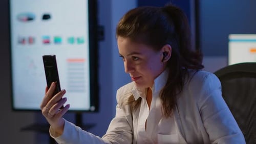 Young Woman on Video Call in Office at Night