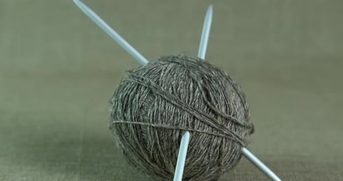 Grey Ball of Yarn with Knitting Needles
