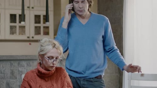 Woman Cooking Vegetables While Man Talks on Phone