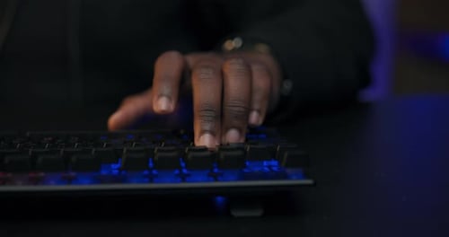 Typing on Illuminated Computer Keyboard at Night