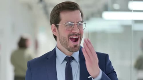 Joven empresario soñoliento bostezando