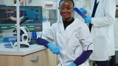 Confident Young Scientist Smiles in Modern Lab