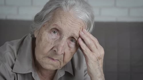 Elderly woman is sad.