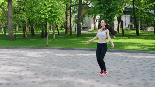 Woman Exercising with Jump Rope in City Park