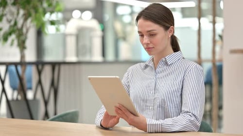 Young Woman Working on Digital Tablet in Office