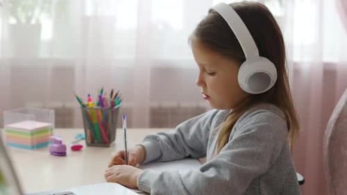 Girl Studying with Headphones at Desk