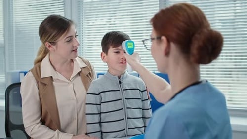 Doctor Consults the Kid Boy with Mother at Appointment at Hospital Female Therapist Measures the