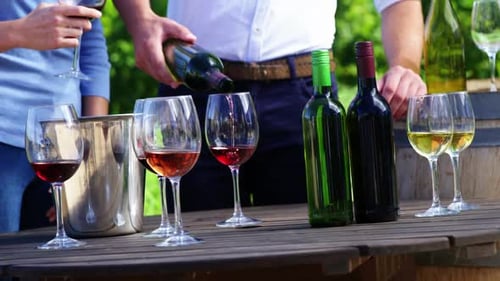 Glücklicher Mann gießt Wein ins Glas