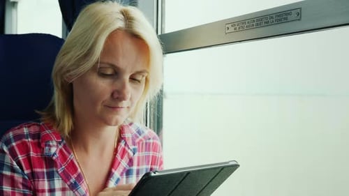 Woman Uses Tablet on Passenger Train