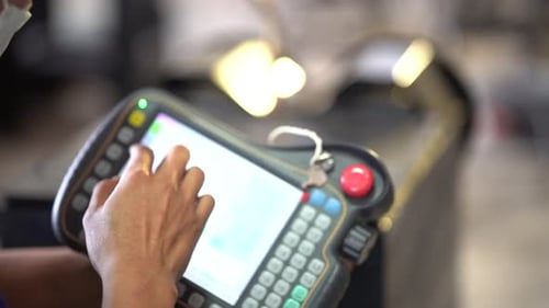 Close-up on A male worker hand is controlling a welding robot.