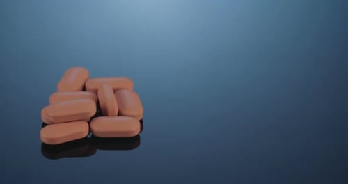 Tan Pills Piled on a Reflective Surface