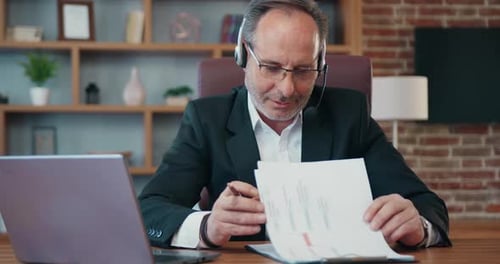 Man Reviews Documents in Modern Office Setting