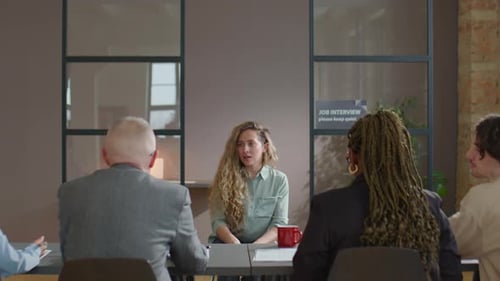 Femme de race blanche parlant avec le comité d'embauche lors d'un entretien