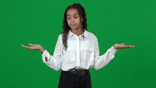 Unsure Puzzled African American Teen Girl Holding Invisible on Green Screen Shrugging Shoulders