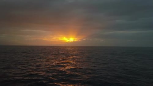 Langsamer Flug über Meereswellen in Richtung eines wunderschönen farbenfrohen Sonnenuntergangs. Drohnenaufnahme von Schönen