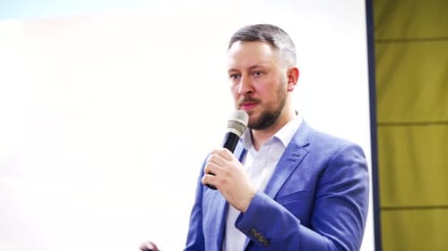 Hübscher Geschäftsmann spricht und zeigt einige Informationen auf dem Bildschirm im Geschäftsforum