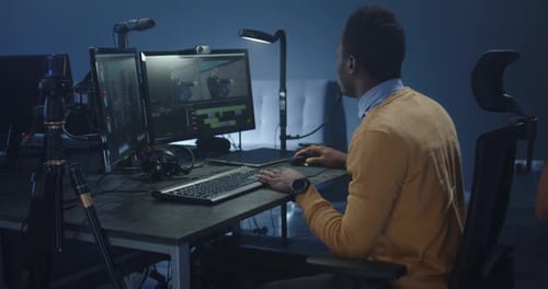 Man Works at Computer in Dark Office