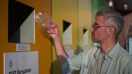 Man Throwing Plastic Waste Into Recycling Bin While Standing on Street on Summer Spbd