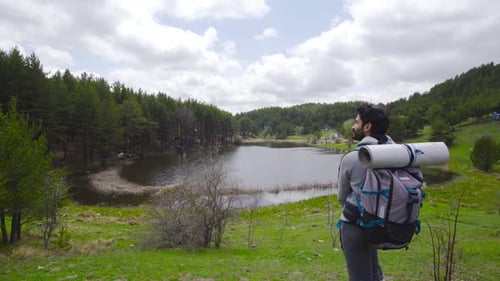 Adult with Backpack Enjoys Serene Lake View