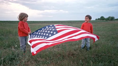 Children Holding American Flag in Field