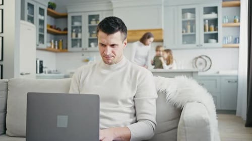 Man Working on Laptop at Home on Couch