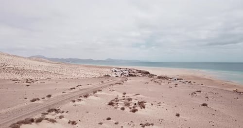 Path road in the middle of a mountains sand desert with blue bright sky in background. Arid climate