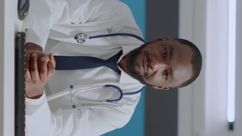 Friendly Doctor Gesturing in Hospital Office