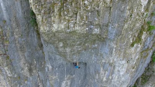 Aerial view of a man rock climbing up a mountain