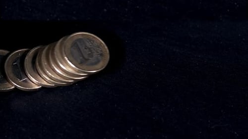 700418 pièces de 1 euros tombant sur fond noir, au ralenti