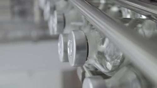 Bouteilles en verre vidéo verticales remplies et scellées avec des bouchons en caoutchouc et en aluminium sur une solution médicale