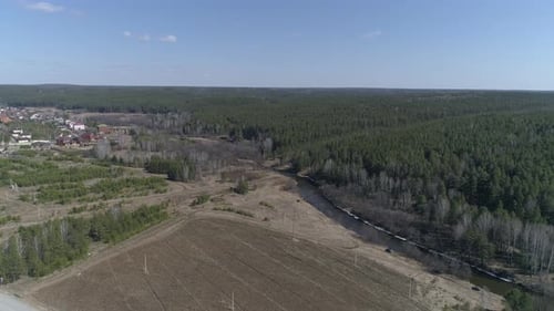 Aerial view of small river between the forest and the field
