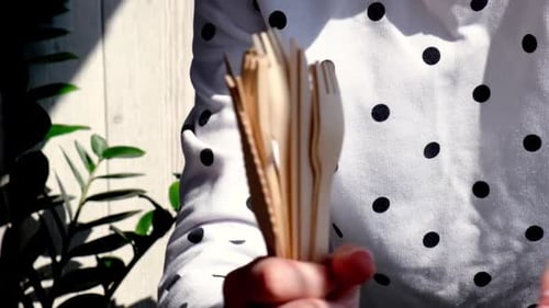 Hand Holding Wooden Spoons, Forks and Knives