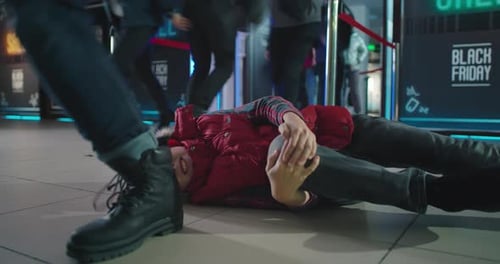 Injured Child Lying on Floor with Crowd Running Into Mall