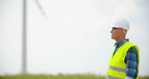 Engineer with Blueprint Analyzing Farm Against Sky