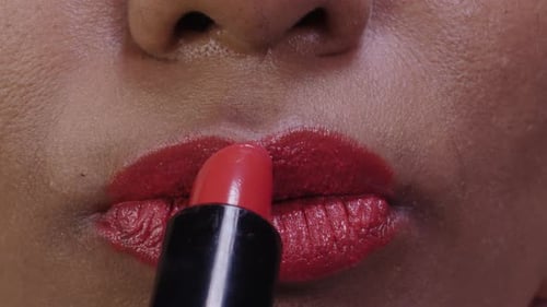 Close-up of Woman Applying Bright Red Lipstick