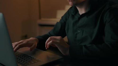 A Man Works on a Laptop in the Home Interior