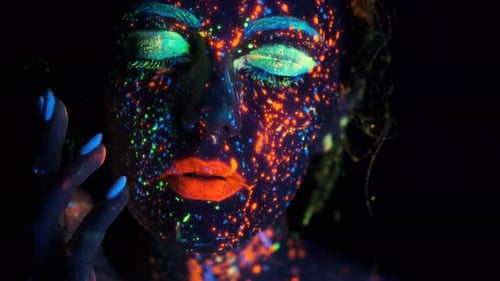 Close-up Portrait in Ultraviolet Light. Face Painted with Glow in the Dark Paint.