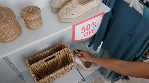 Mujer agarrando el último par de zapatos en la tienda