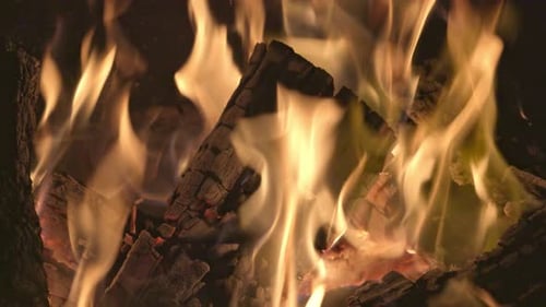Ein hell loderndes Lagerfeuer verbrennt das geschwärzte Brennholz und die Wände des Grills