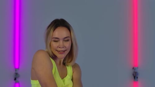 Smiling Young Woman Posing with Neon Lights