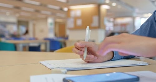 Woman write on the paper at library