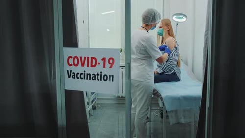 Female Doctor Making Vaccination Against Coronavirus in District Hospital