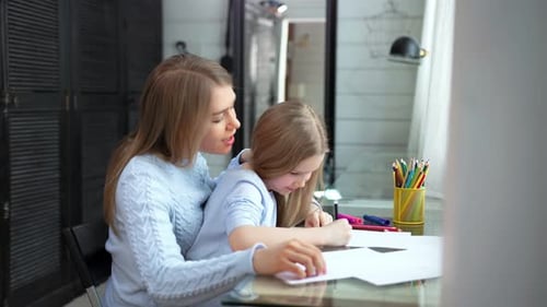 Woman and Child Drawing Together at Table