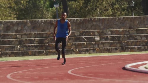 Male Athlete Running on Track and Field on Sunny Day