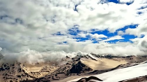Majestic Mountain Peaks and Billowing Clouds Aerial View